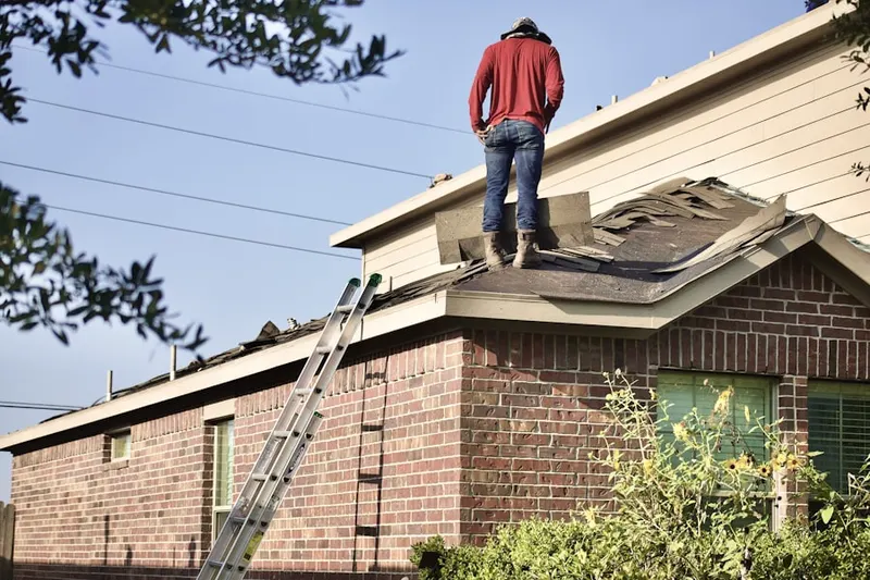 Professional roofer working on a residential roof in Golden Meadows
